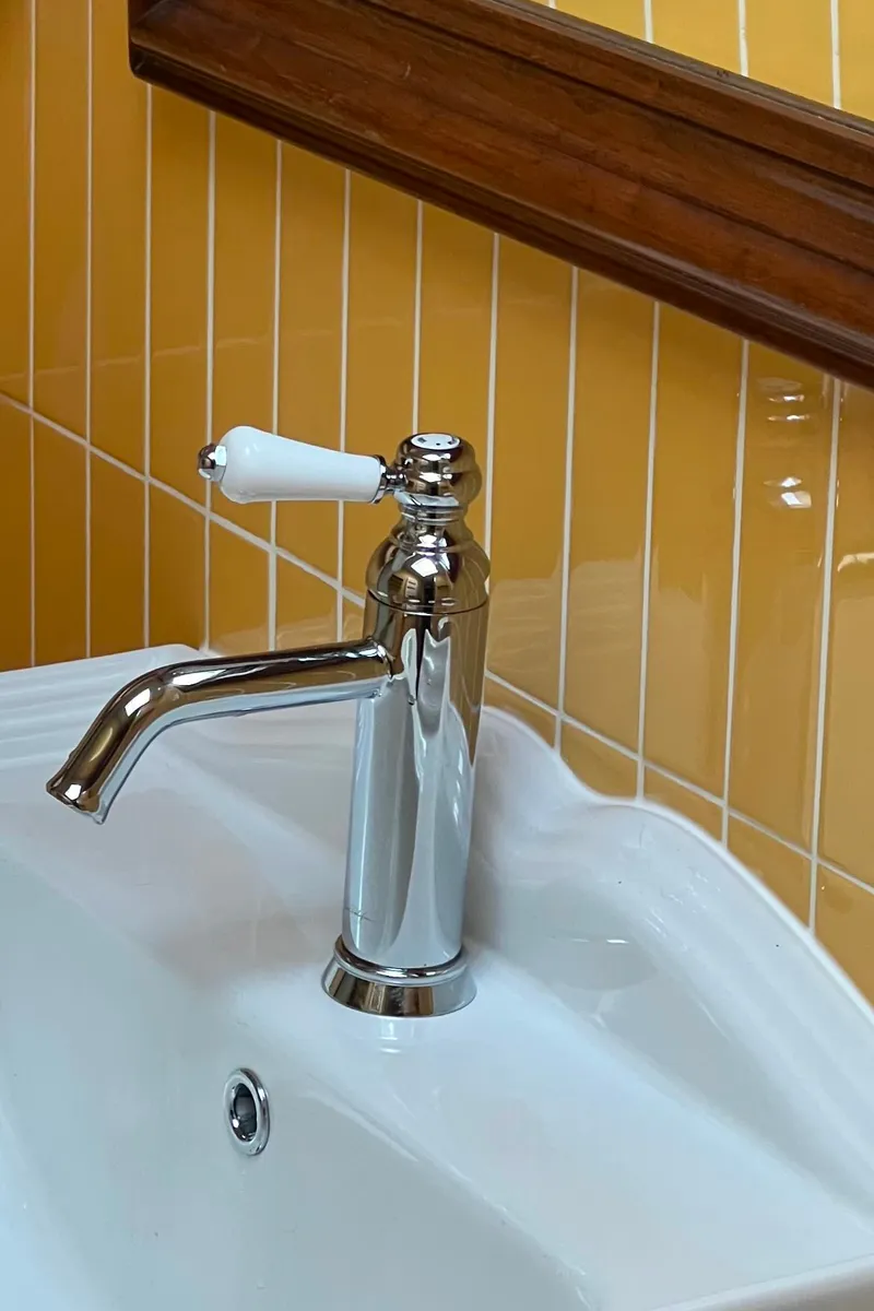 Robinetterie rétro chromée sur lavabo colonne